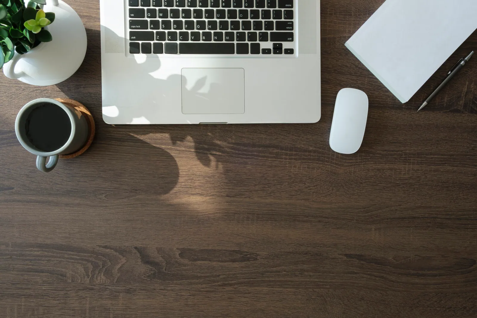 Desk with laptop, coffee, and planning notes for a website project